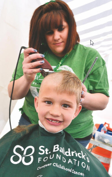 Sawyer Rocchio smiles as he gets his hair cut by Jamie Owens, owner of Jalyn Styles, during the previous St. Baldrick's Foundation's haircutting event at Jimmy's Tavern in Pueblo West to help battle childhood cancer. [FILE PHOTO]